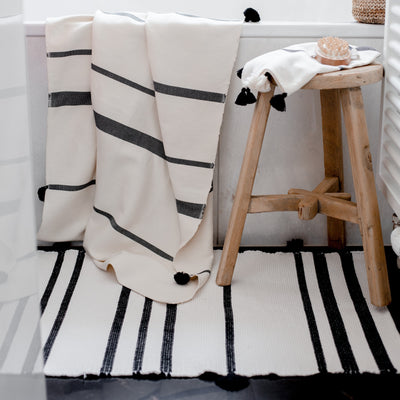 Bathroom decor with black and cream stripe bath towels and matching bath rug from artha collections