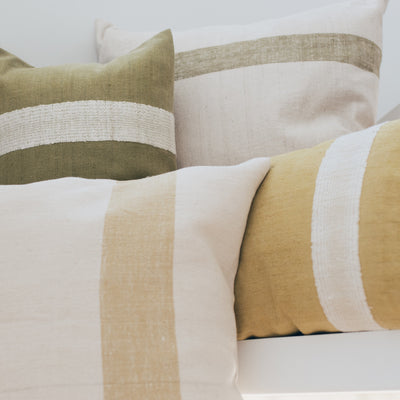Collection of decorative throw pillows with yellow and green naturally dyed stripe designs