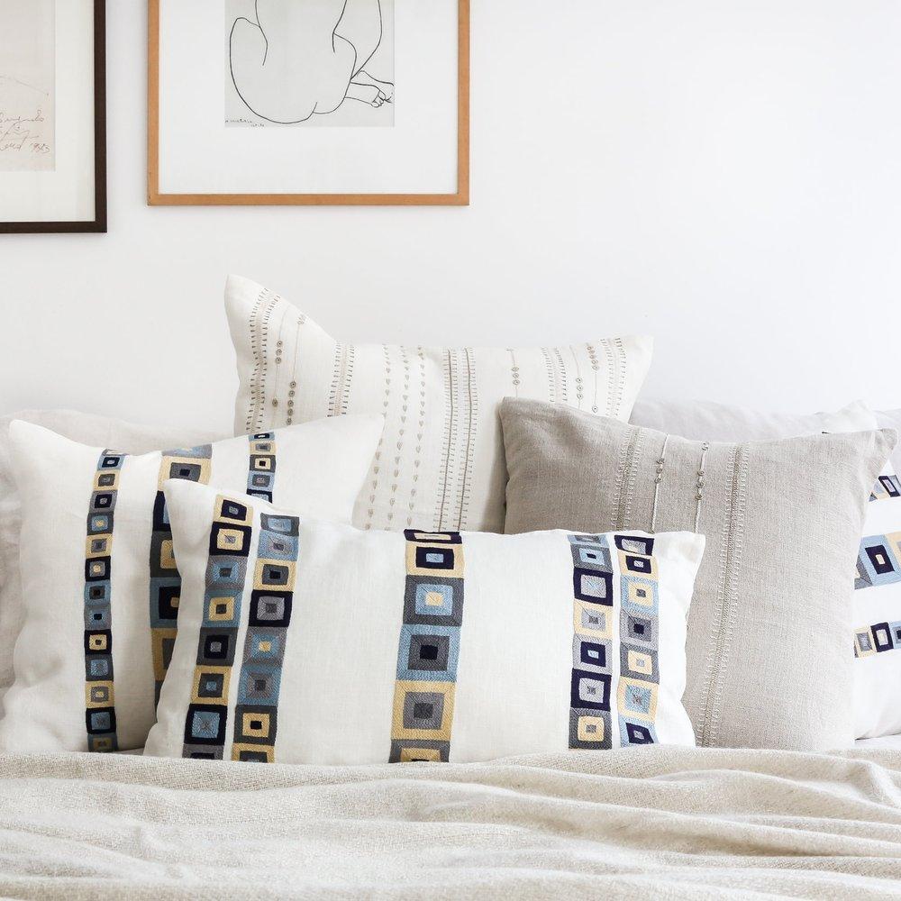 Linen throw pillows with a hand embroidered  blue and tan geometric design by Artha Collections