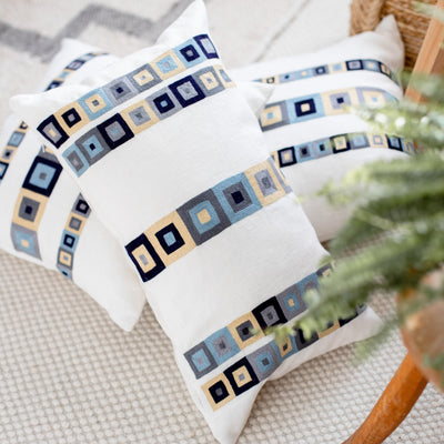 Linen throw pillows with a hand embroidered  blue and tan geometric design by Artha Collections