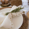 Banana fiber round placemat table setting with hand embroidered linen napkin in cream