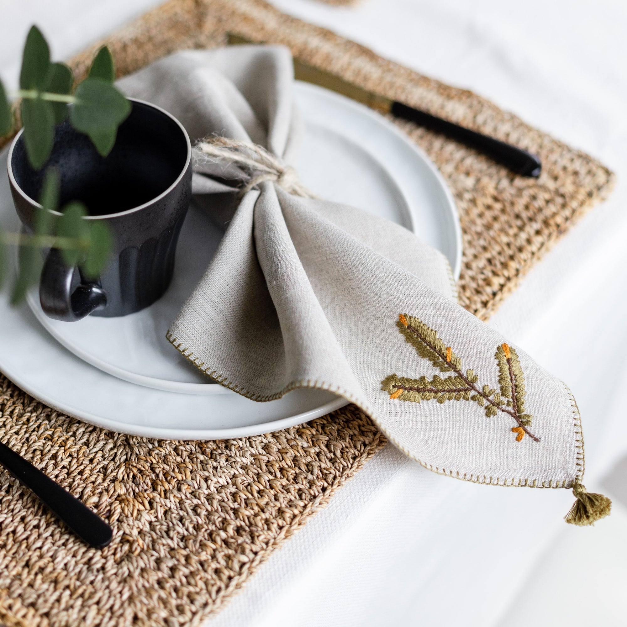 beige linen napkin with evergreen branch motif by artha collections